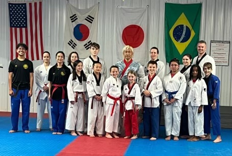 A group of people are posing for a picture in front of flags.