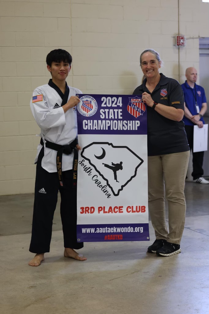A man and a woman are holding a sign that says 2024 state championship.