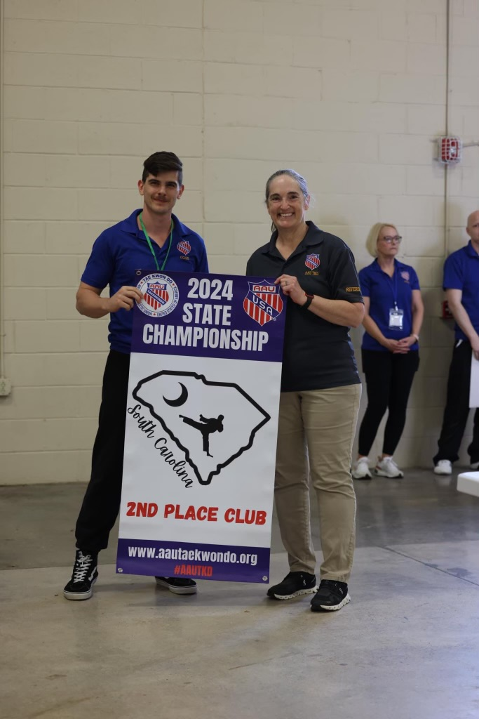 A man and a woman are holding a sign that says 2024 state championship.