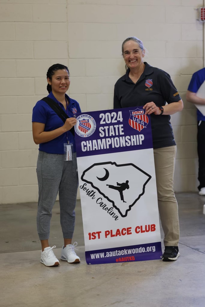 Two women are holding a sign that says `` 2024 state championship ''.