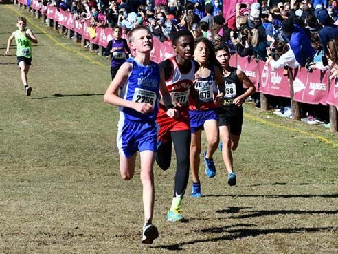 A group of young boys are running a cross country race.