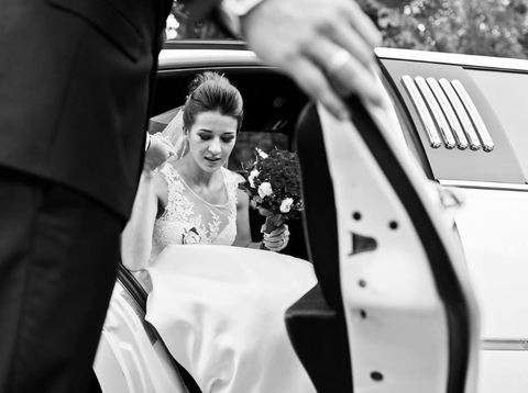 Chauffeur helping a bride out of a wedding limo on Long Island, NY