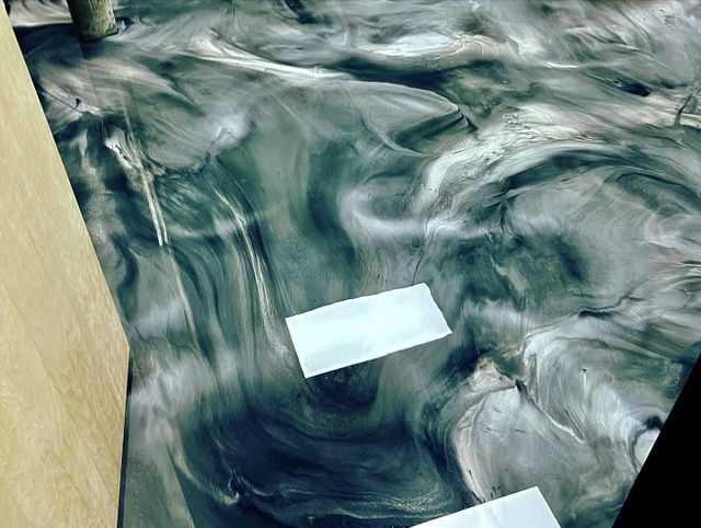 metallic epoxy floor with a combination of dark green and white colors pattern