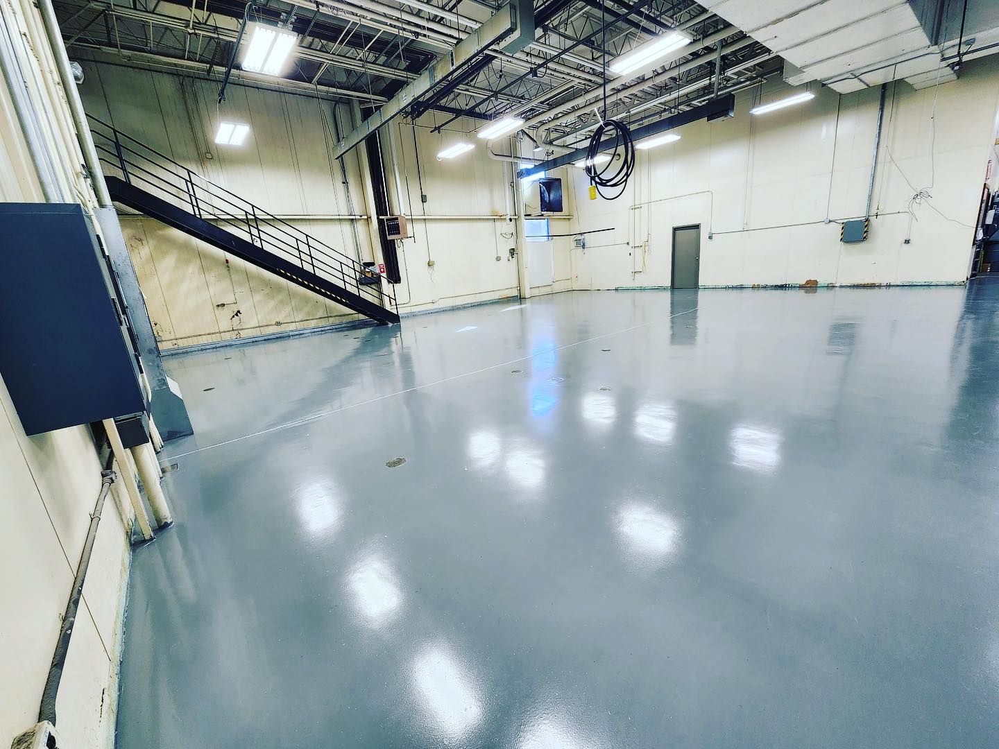 worker pouring gray epoxy resin to the floor
