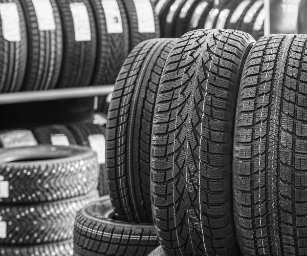 A black and white photo of a stack of tires in a store.