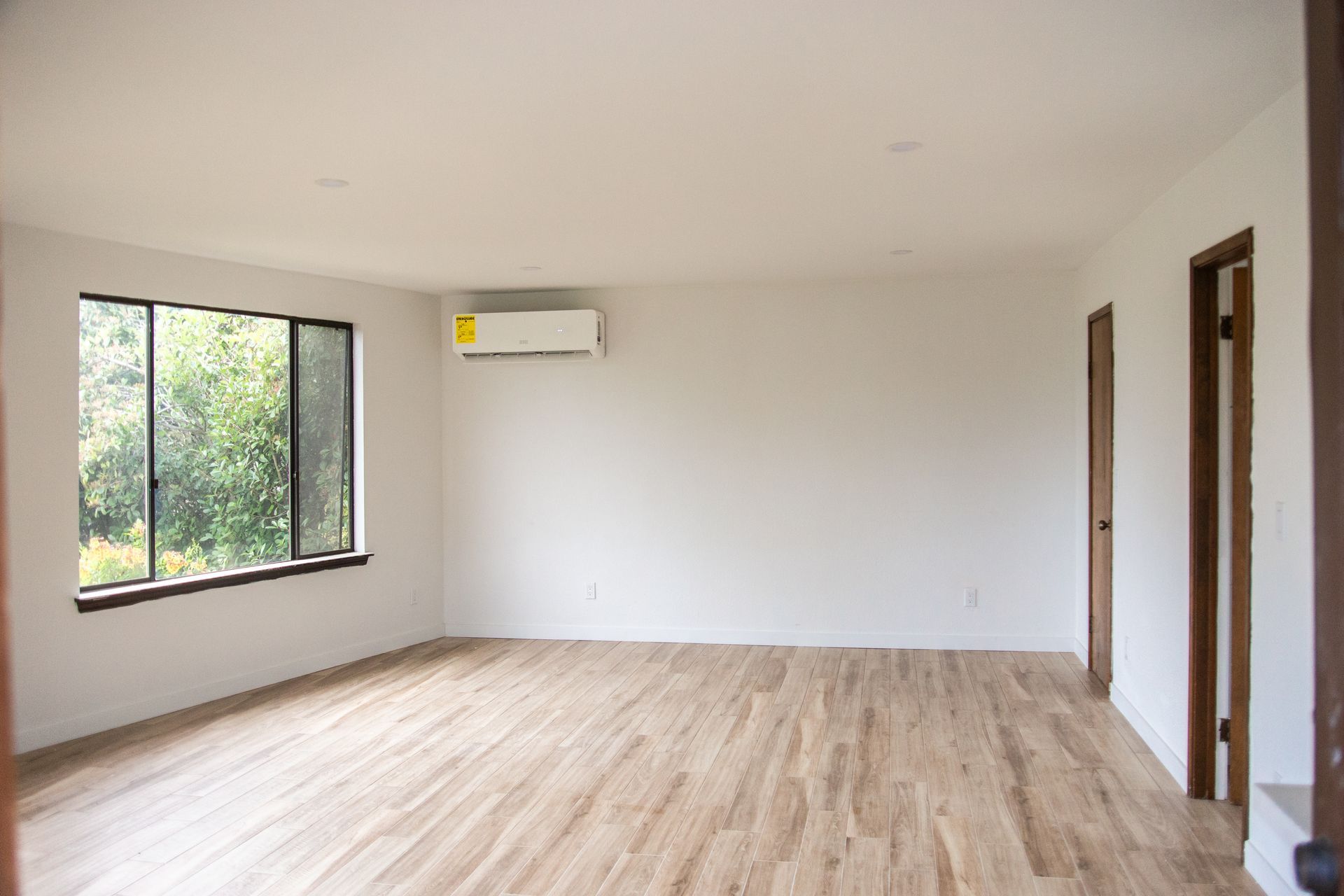 A remodeled ADU living room with hardwood floors and white walls.