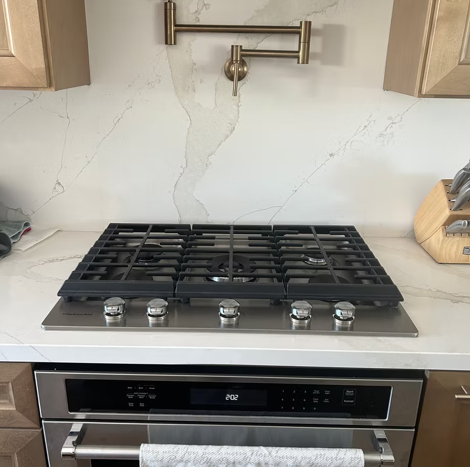 A stove top oven is sitting on top of a counter in a remodeled modern kitchen.
