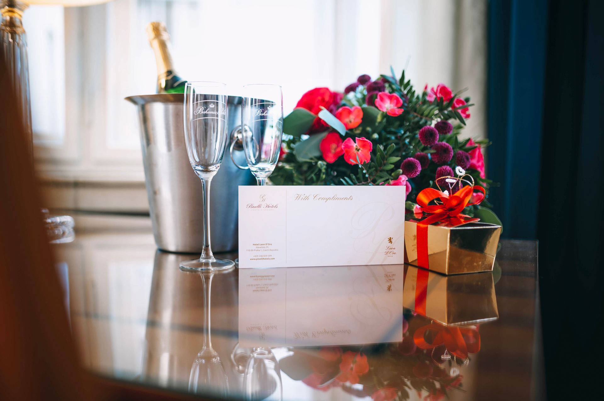 Florist arranging a bouquet of pink and cream-colored flowers against a black brick wall backdrop.
