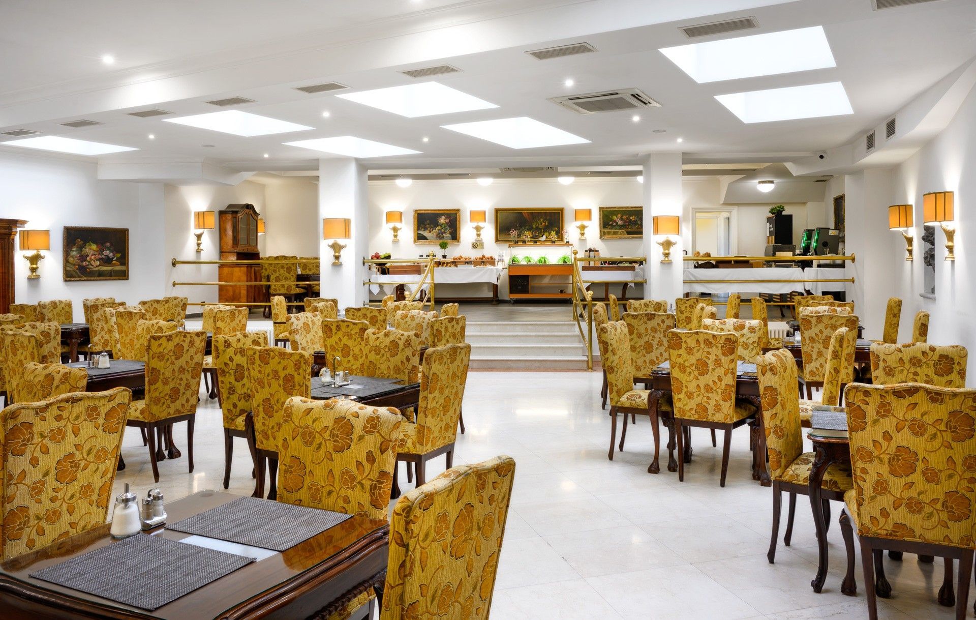 Rooftop view of European city with buildings, blue sky, and a distant hill.