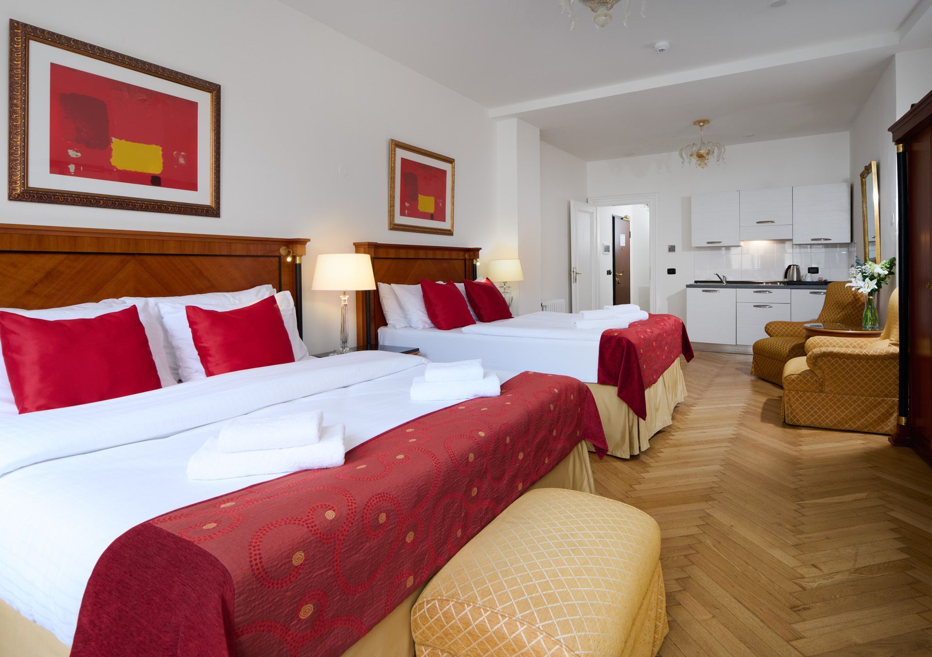 Bedroom with a gold velvet bed, nightstand, painting, and a table.