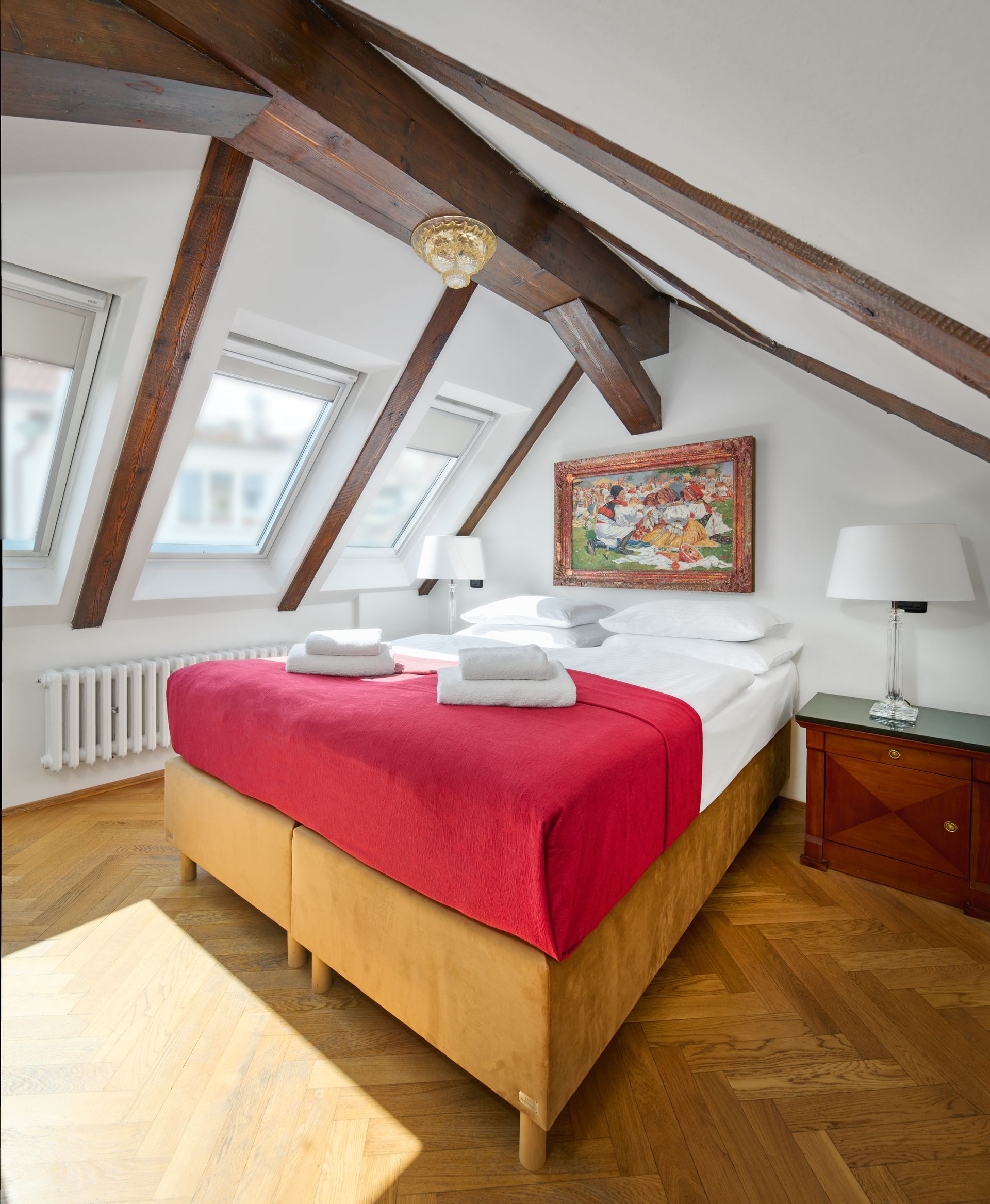 Bedroom with ornate wooden bed, red carpet, white walls, and blue curtains.