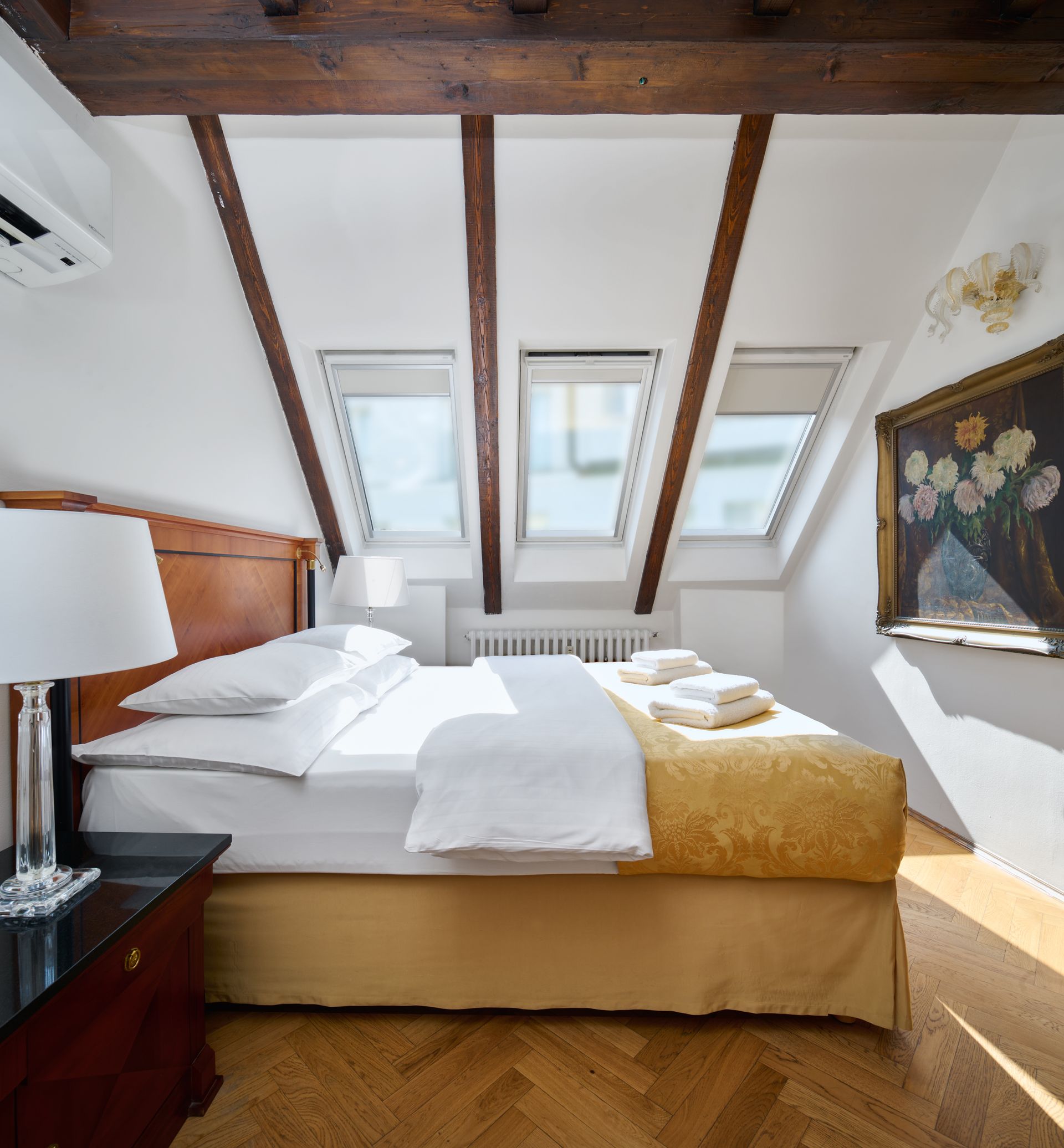 Hotel suite with red carpet, table and chairs, and balcony.