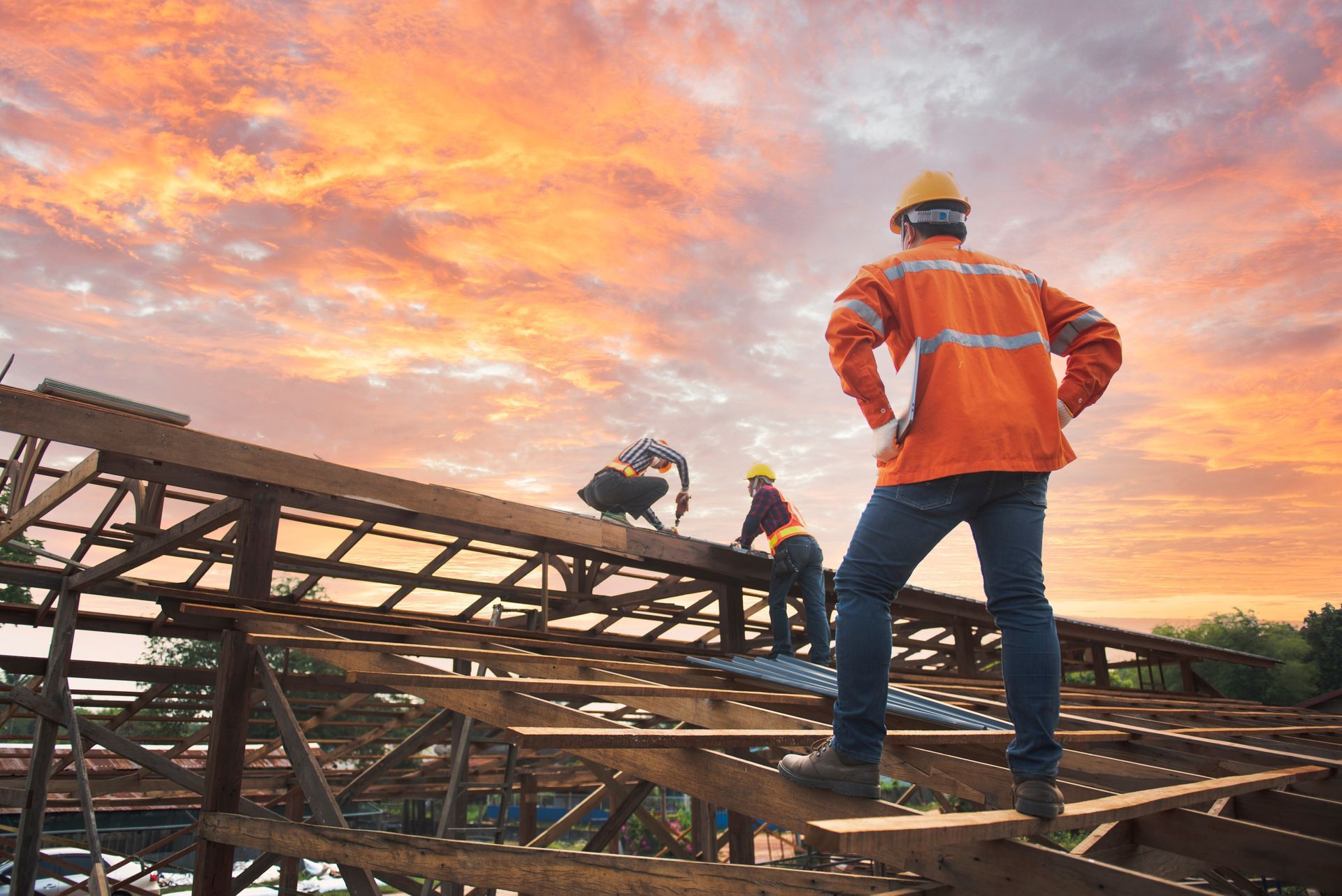 A group of construction workers are standing on top of a wooden structure.