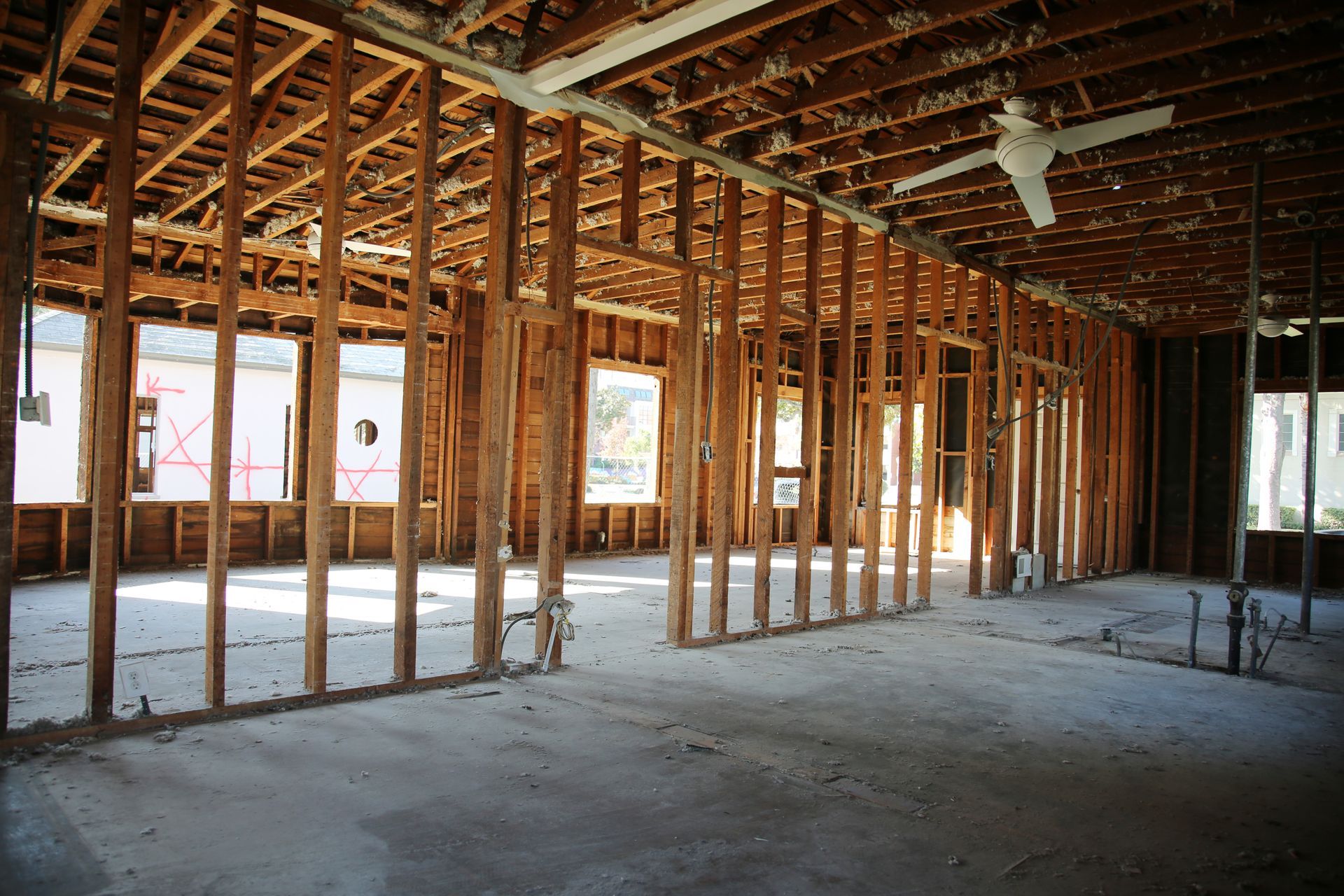 An empty room with wooden beams and a ceiling fan