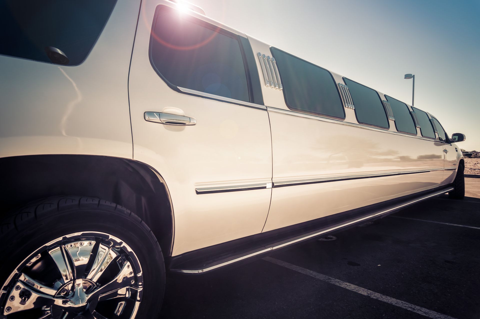 A white limousine is parked in a parking lot.