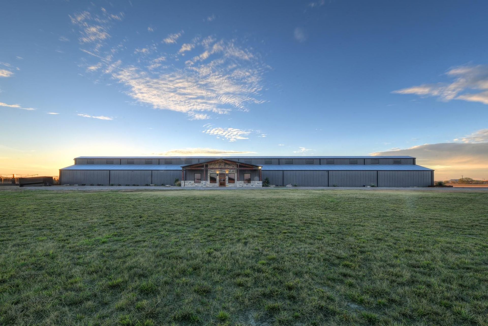 A large building is sitting in the middle of a grassy field.