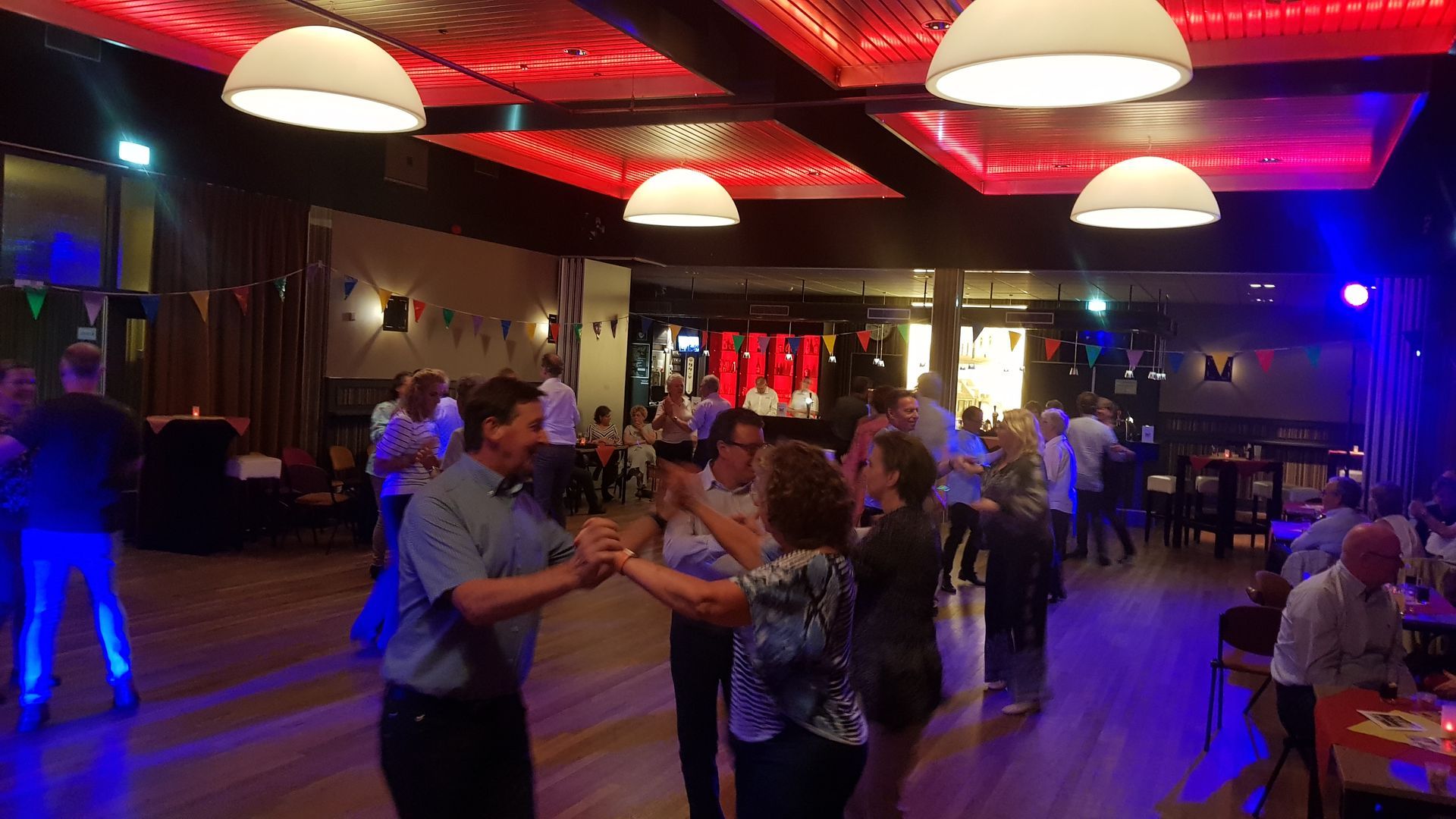 Workshop: Mensen dansen in een zaal, met de roze tekst 