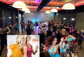 Mensen dansen in een balzaal met een Zumba-instructeur.  30-plussers en 50-plussers.