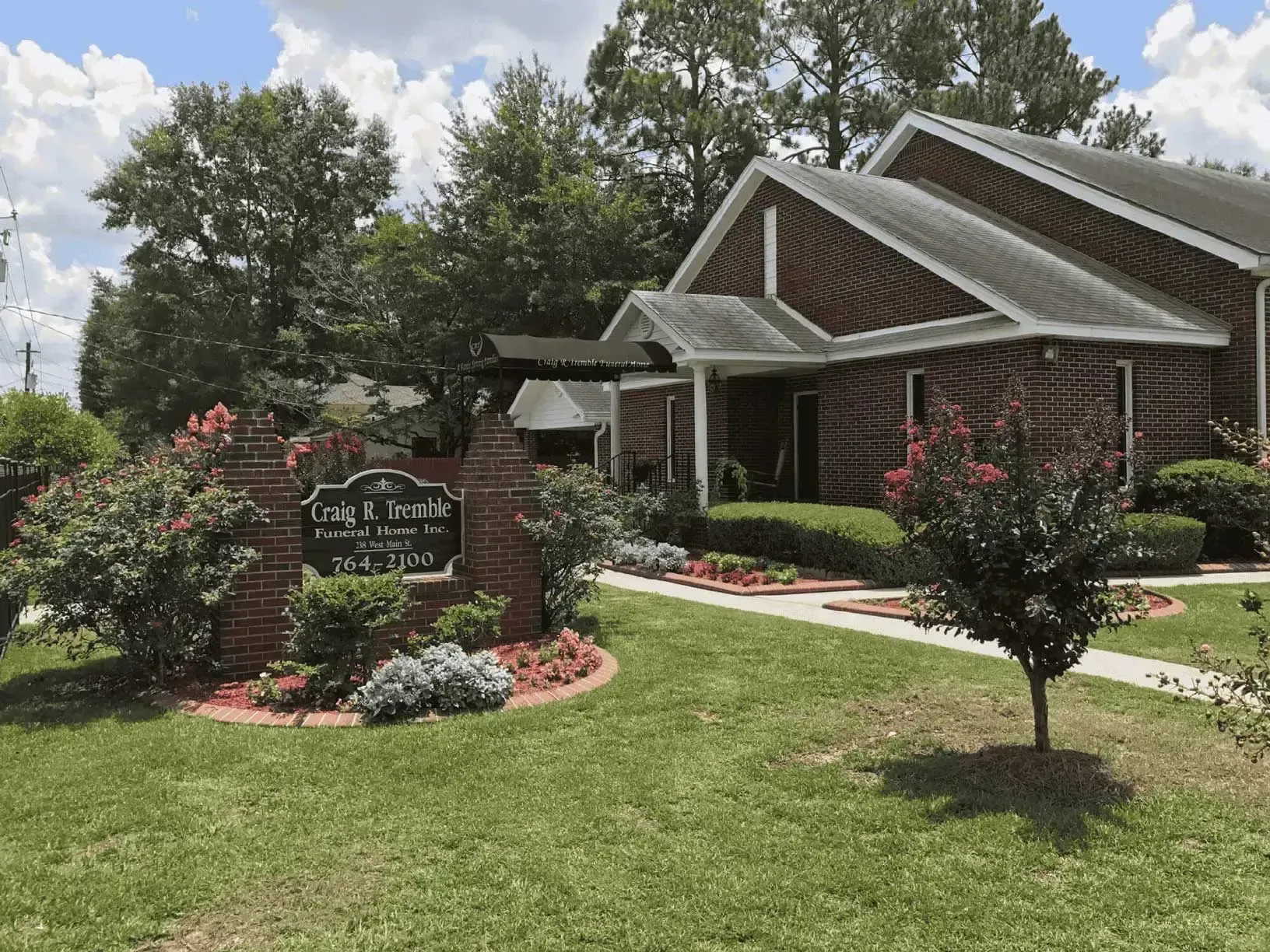 Brick building with a sign and landscaping.