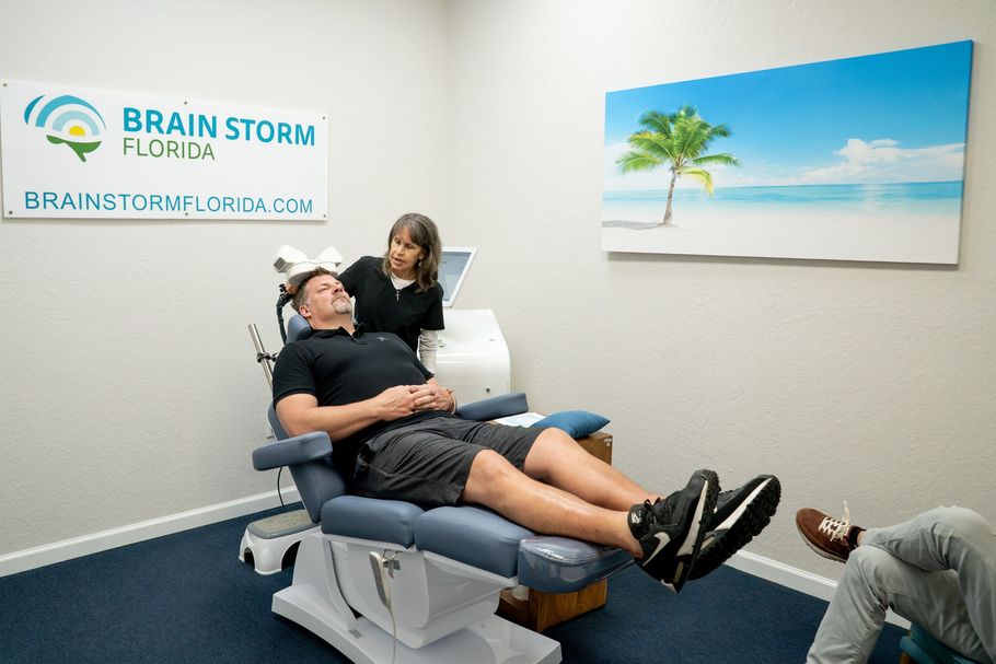 Man receiving medical treatment in a Brain Storm Florida clinic, with staff present.