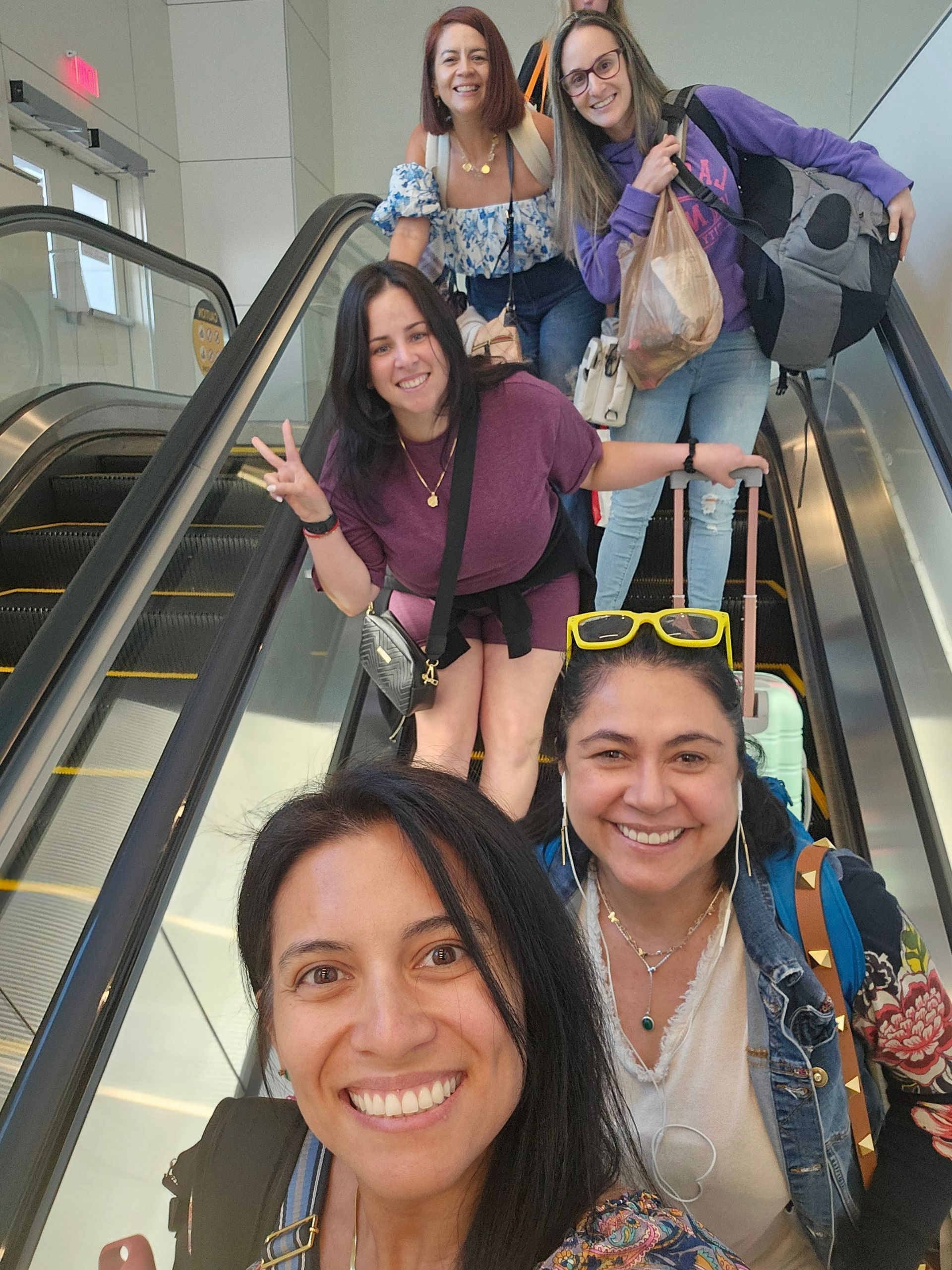 A group of women are standing on an escalator.