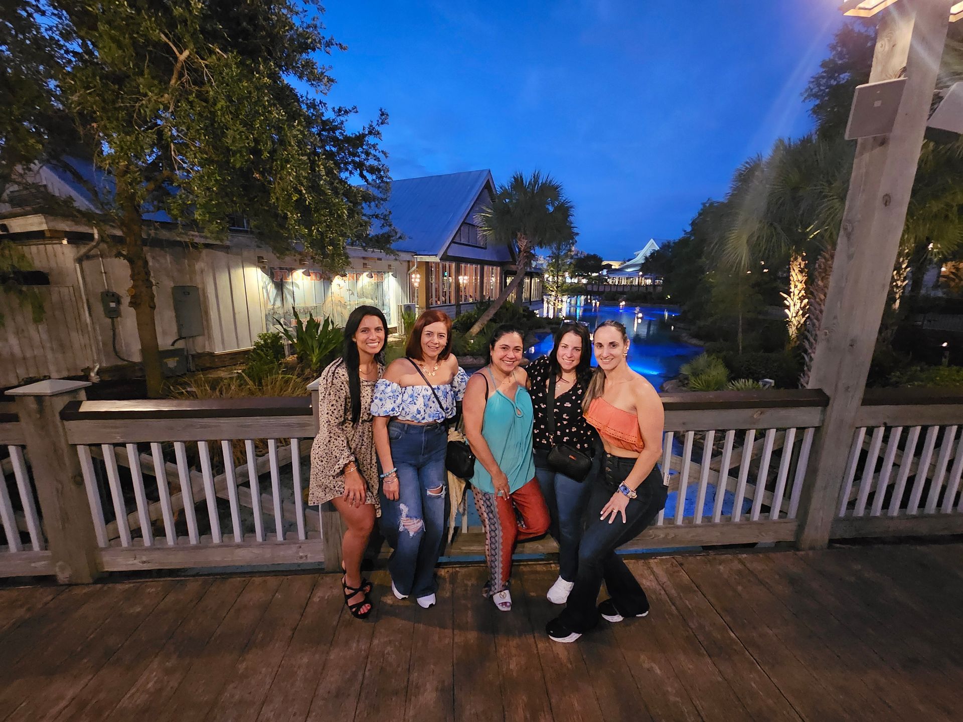 A group of women are posing for a picture on a bridge.