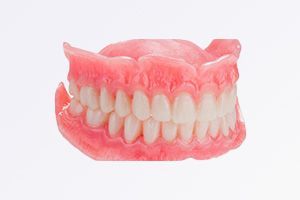 A close up of a denture on a white background.