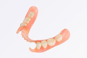 A close up of a denture with teeth on a white background.