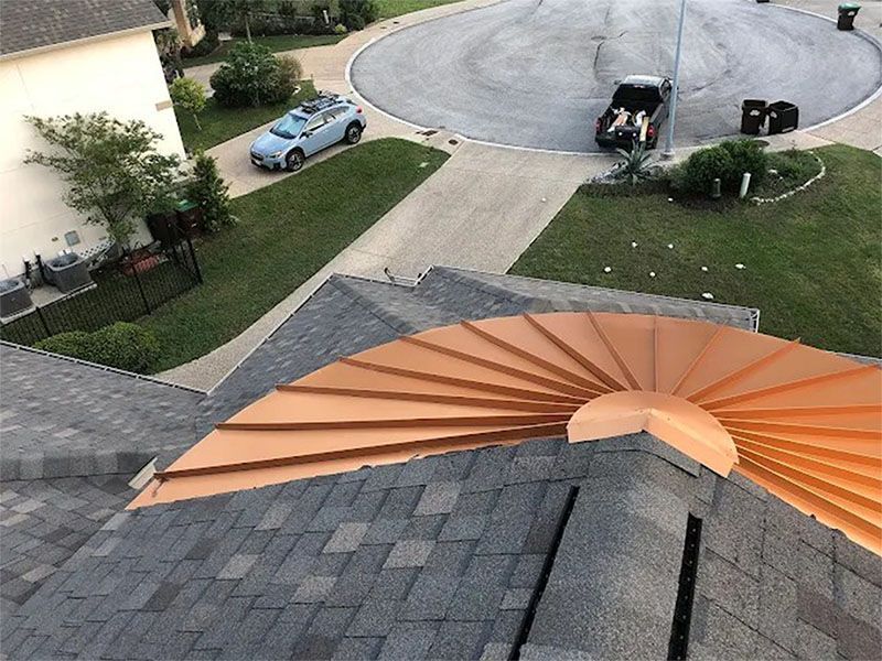 An aerial view of a roof with a copper fan on it.