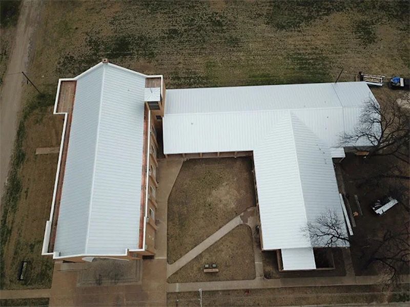 An aerial view of a building with a white roof.