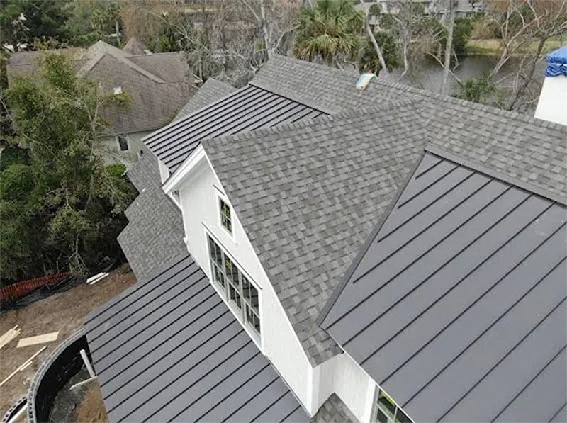 An aerial view of a house with a black roof.