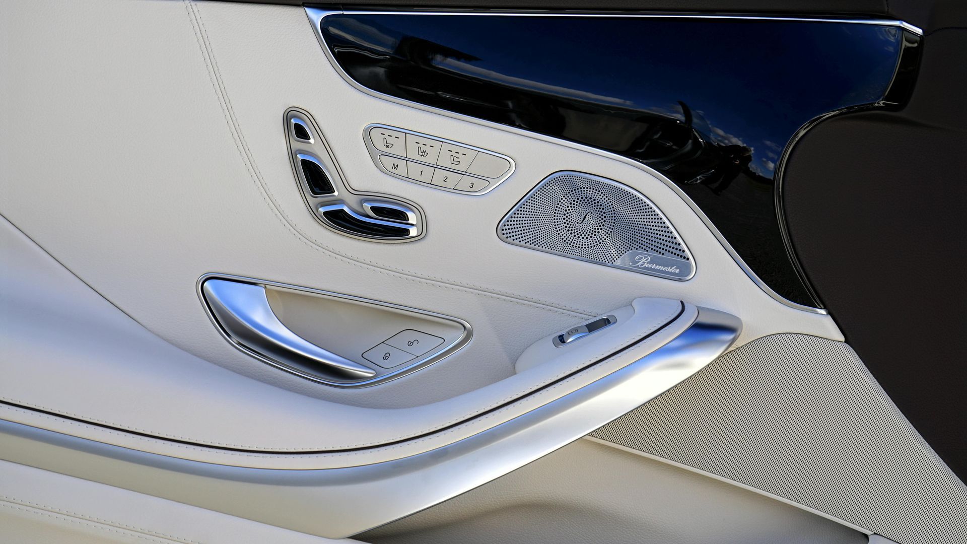 White car door interior with chrome accents and seat controls.