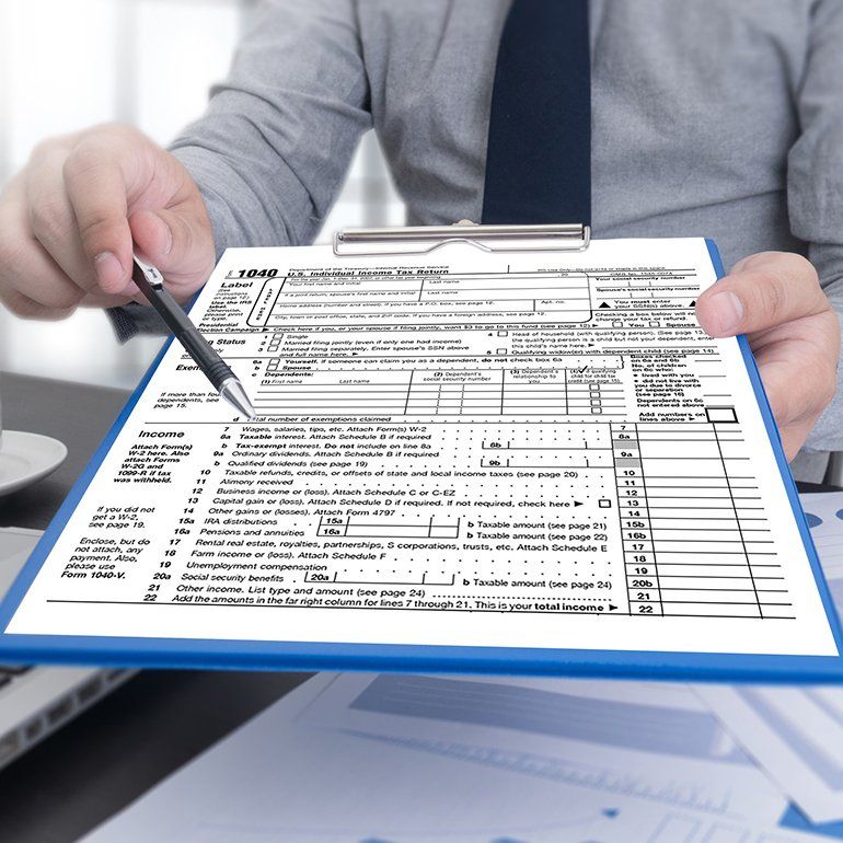 Business Man Holding A Tax Form — Hot Springs, AR — Malone Tax & Bookkeeping