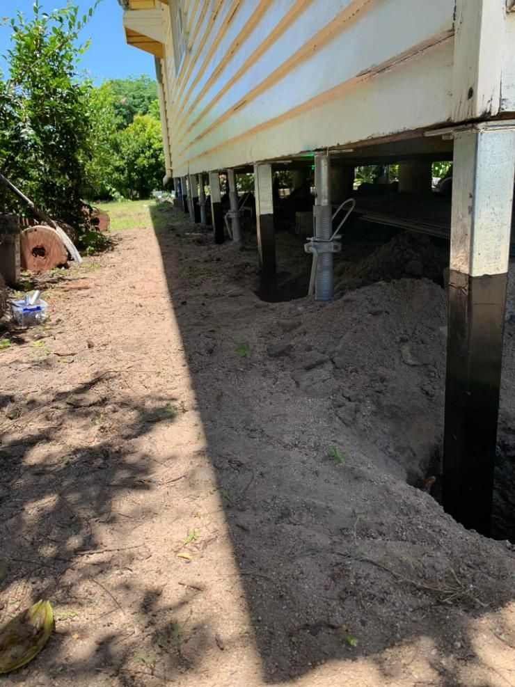 A House Is Sitting on Stilts in The Dirt — Get Stumped Stumping & Maintenance In Bowen, QLD