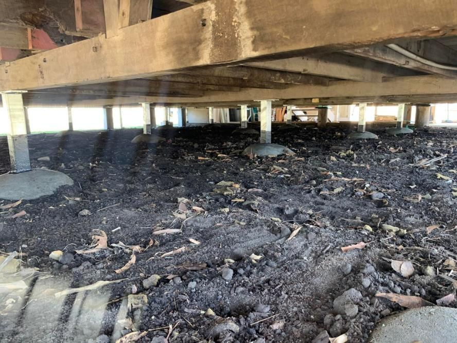 A Wooden Structure with A Lot of Dirt Underneath It — Get Stumped Stumping & Maintenance In Collinsville, QLD