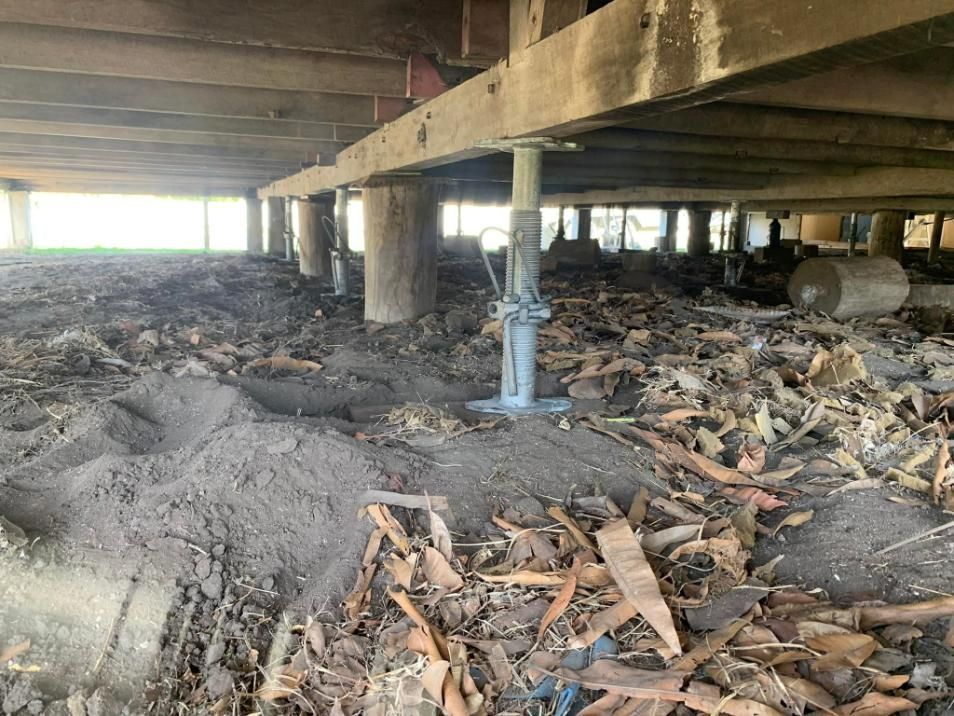 A Pile of Dirt and Leaves Under a Wooden Structure — Get Stumped Stumping & Maintenance In Bowen, QLD