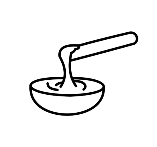 Hand dipping a spoon into a bowl of liquid or batter