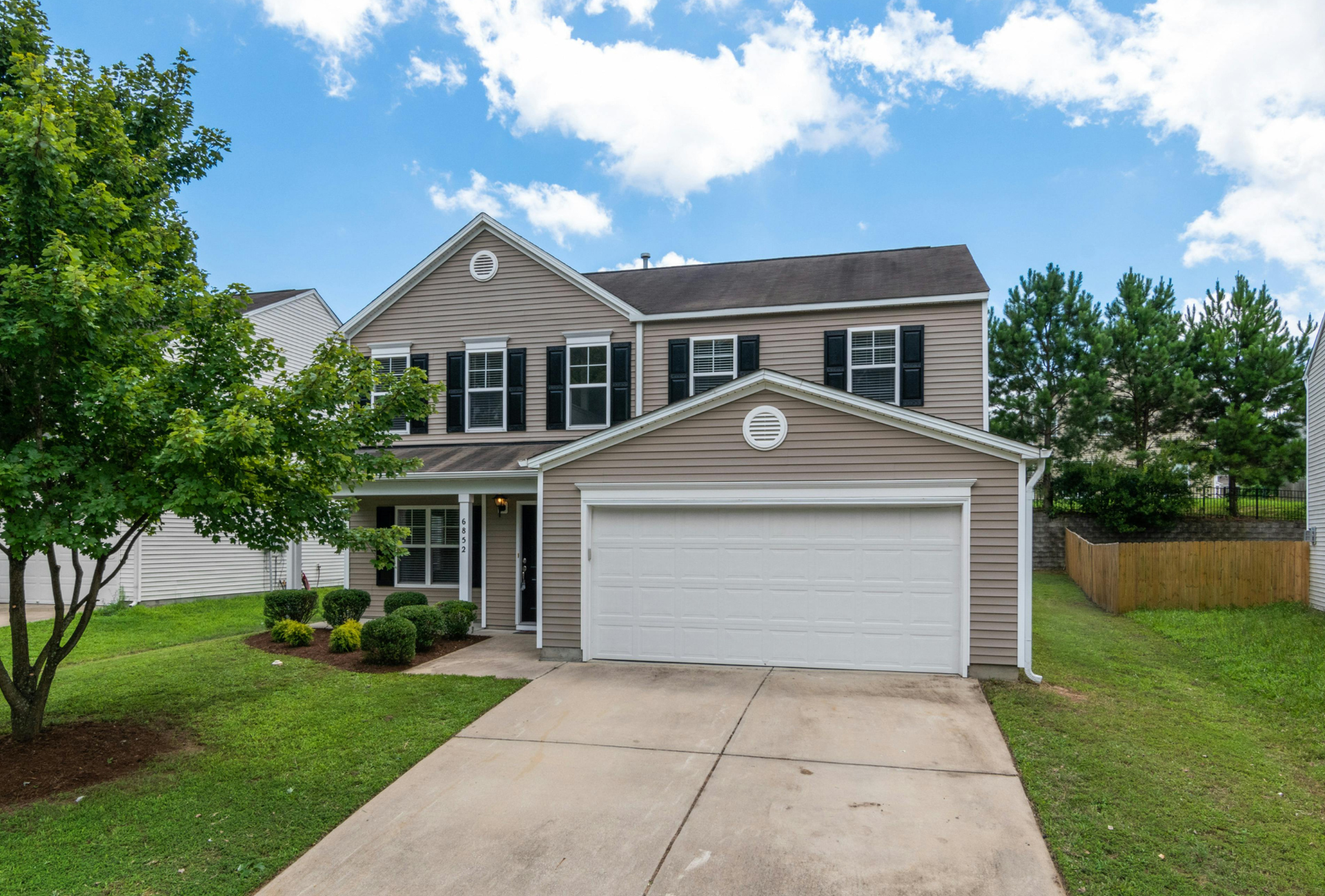 A large house with a white garage door and a driveway