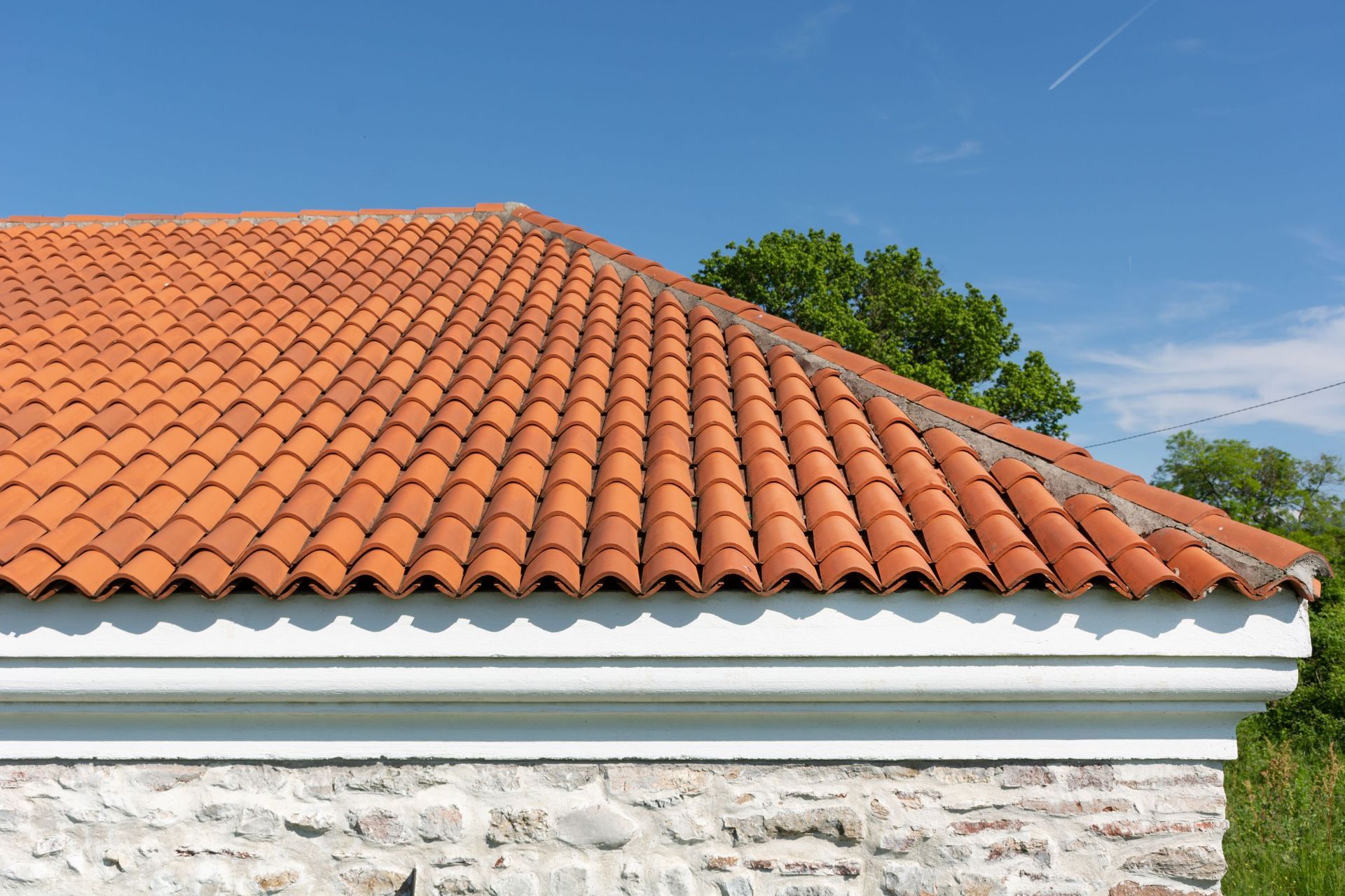 A house with a tiled roof and a stone wall