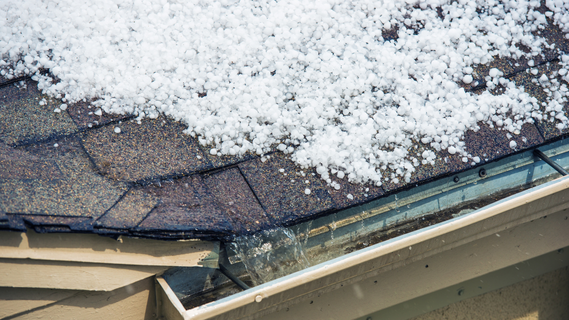 There is a lot of snow on the roof of a house.