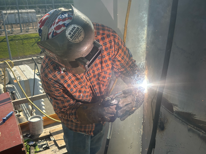 A man welding metal to complete a project. 