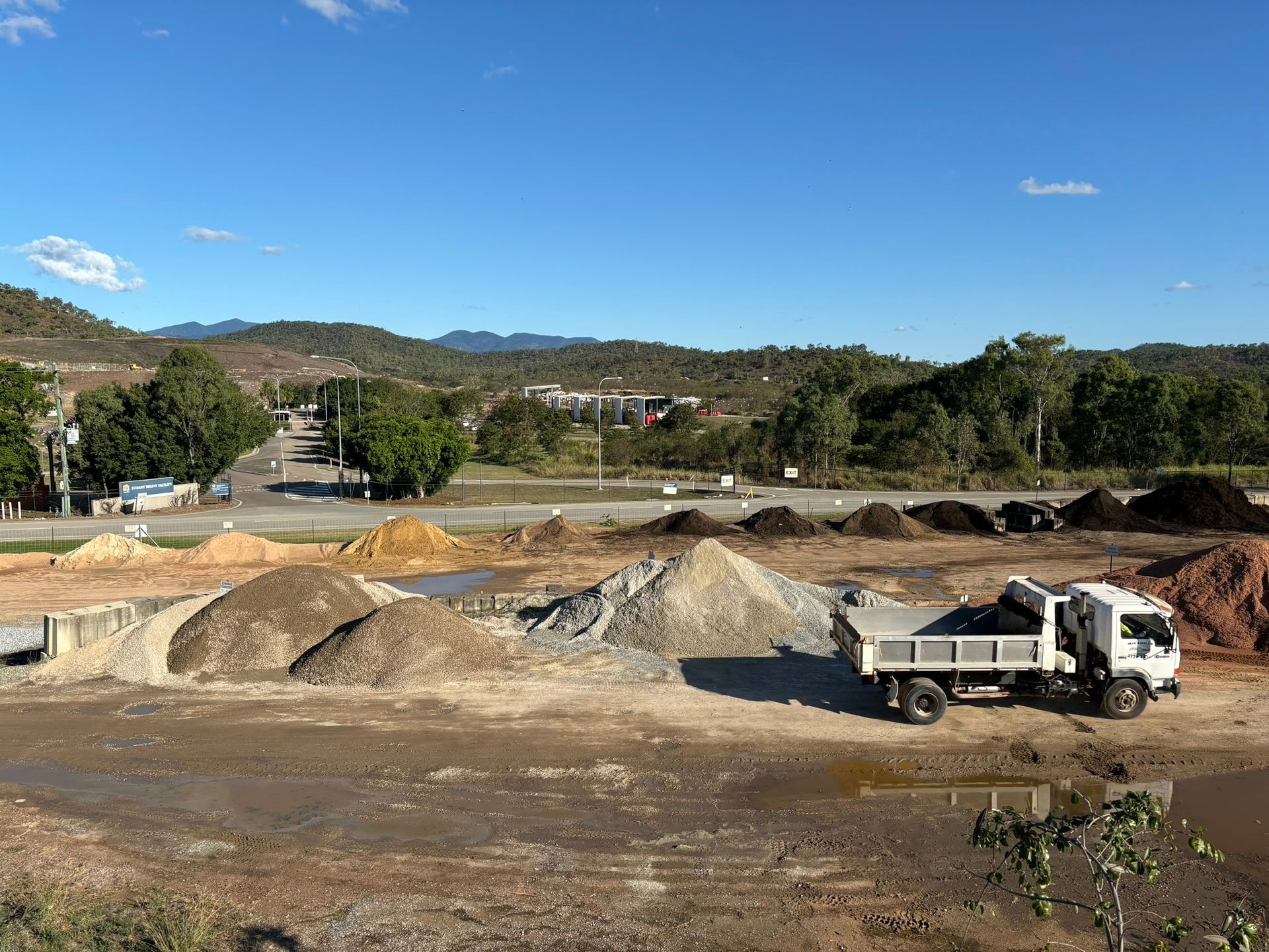 White Semi Truck of McCahills Parked In Front Of Rock Piles— McCahills Earthmoving & Landscaping Supplies In Stuart, QLD