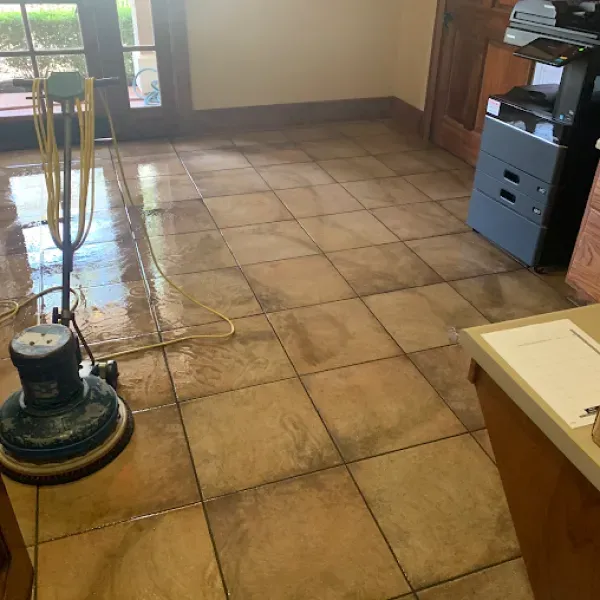 A vacuum cleaner is sitting on a tiled floor in a kitchen