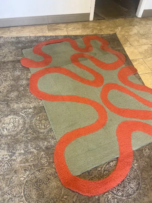 A rug with a red swirl pattern on it