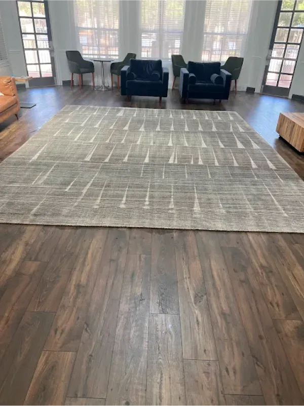 A living room with hardwood floors and a rug on the floor.