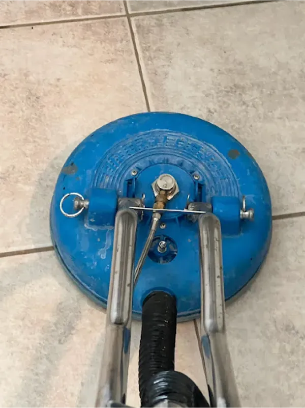 A blue vacuum cleaner is sitting on a tiled floor.