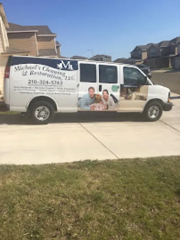 A white van with a picture of a family on the side is parked on the side of the road.