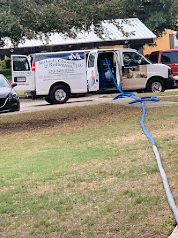 A van is parked on the side of the road next to a hose.