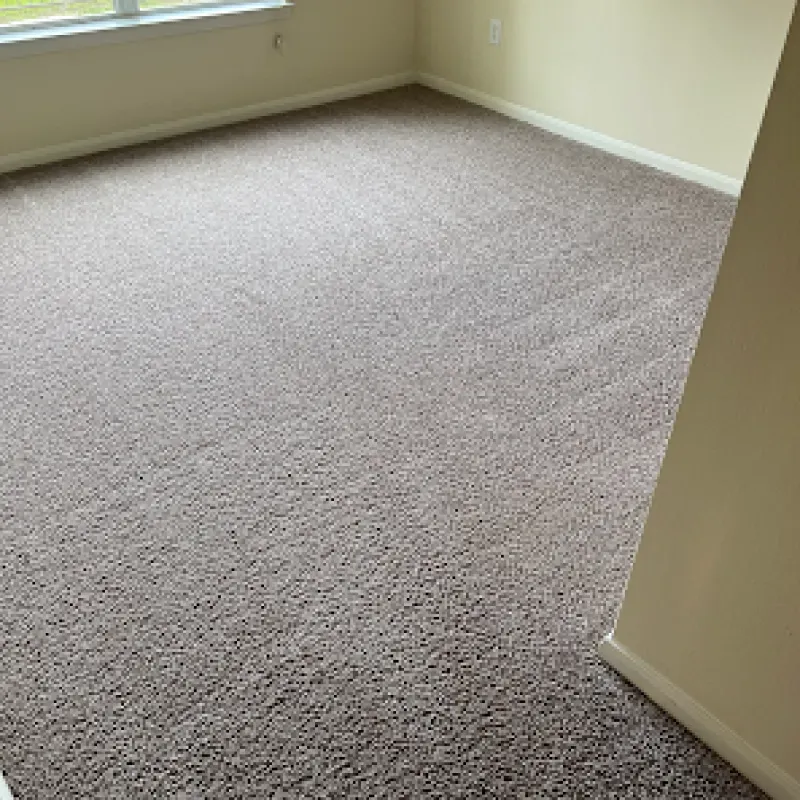 A room with a large carpeted floor and a window.