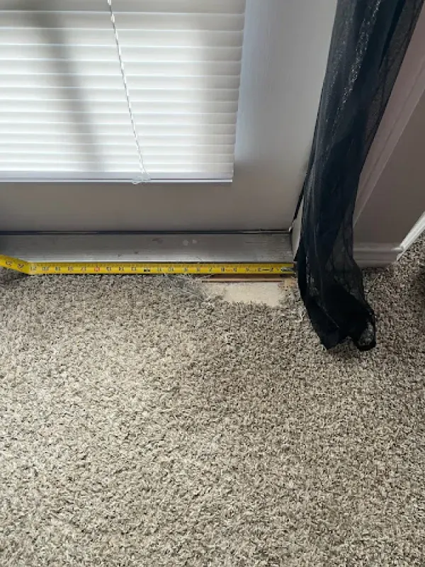 A person is measuring a door with a tape measure.